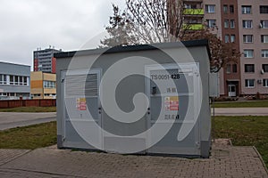 Electric transformer room building with gray doors and yellow danger signs against the blue sky in the city of Nitra in Slovakia