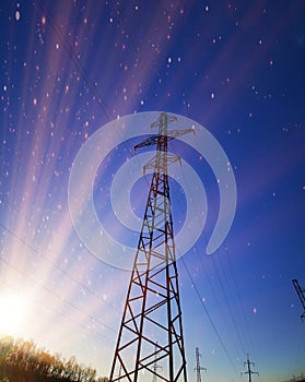 Electric transmission line. Power transmission pylon silhouette against blue sky at dusk. The concept of electrification