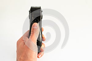 Electric trimmer in a hand on a white background