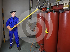 Electric uses an insulating stick for grounding transformer.