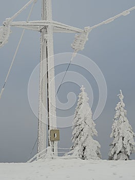 An electric utility pole in the Swiss Jura mountains in deep snow