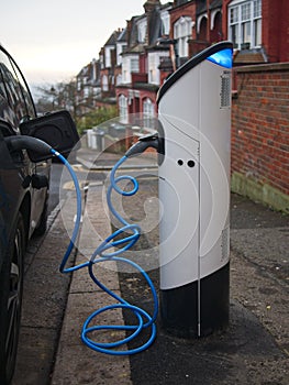 An electric vehicle being charged at a charging station at a residential street in London, UK