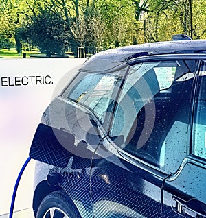 Electric vehicle being plugged in