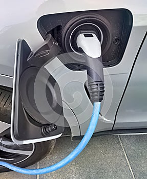 Electric vehicle being plugged in