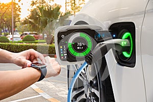 Electric vehicle changing on street parking with graphical user interface synchronize with smart watch, Future EV car concept