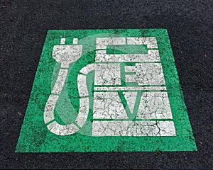 Electric vehicle charge sign painted on the tarmac in a car park
