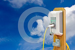 Electric vehicle charging Ev station and plug of power cable supply for Ev car on blue sky and cloud background with copy space