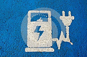 Electric vehicle charging public station sign on blue painted asphalt .