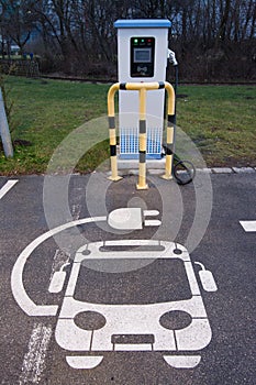 Electric vehicle charging station sign in a parking bay