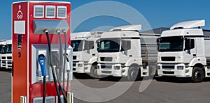 Electric vehicles charging station on a background of a row of trucks
