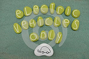 Electric Vehicles Only text with green colored stones over green sand photo