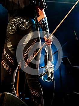 Electric violin in the hands of a beautiful woman musician, rock concert