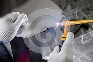 An electric welder wearing gloves is welding stainless steel products, indoor environment, sparks flying