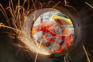 Electric wheel grinding at Industrial worker wear a safety mask cutting metal pipe with many sharp sparks