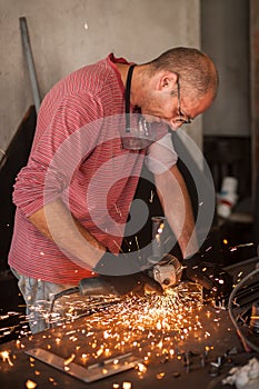 Electric wheel grinding on steel structure in factory