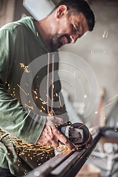 Electric wheel grinding on steel structure in factory