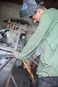 Electric wheel grinding on steel structure in factory