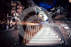 Electric wheel grinding on steel structure in industrial factory. worker cutting steel