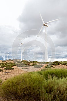 Electric wind mills moved by the wind over cloudy sky background