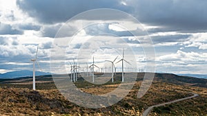 Electric wind mills moved by the wind over cloudy sky background