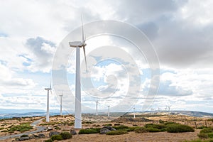 Electric wind mills moved by the wind over cloudy sky background