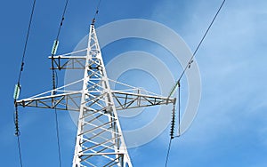 Electric wires against the blue sky with clouds. High voltage power line. Electricity transmission pylon. The concept of the