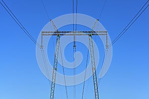 Electric wires against the blue sky. High voltage powerline tower