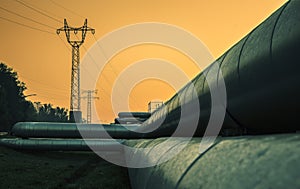 Electric wires and district heating tubes at sunrise photo