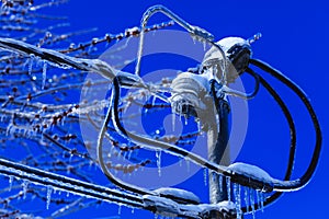 Electrical box installation with crystal icicles hanging from the wires. Weather winter disaster in North America. Ice catastrophe