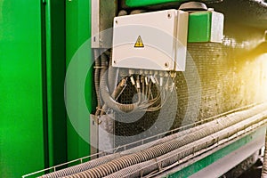 Electrical cabinet in an industrial plant and a warning sign of electricity. Electric wires and cables. High voltage