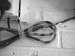 ELECTRICAL CABLE ON WHITE BRICK WALL