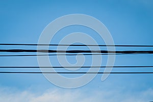 Electrical cable wire with blue cloudy sky as background