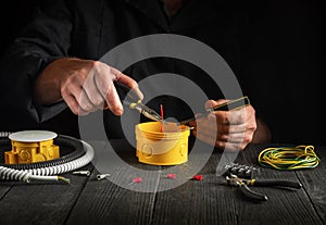 Electrical connection or repair in a professional electrician workshop. Close-up of the hands of an electrician during work