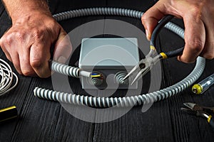 Electrical connection in the workshop of a master electrician. Close-up of hands of a master electrician during work. Installing a