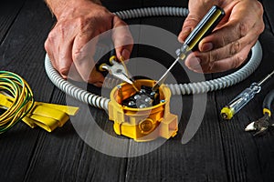 Electrical connection in the workshop of a master electrician. Close-up of hands of a master electrician during work. Installing a