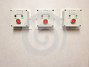 Electrical control panel with red button on concrete wall, closeup