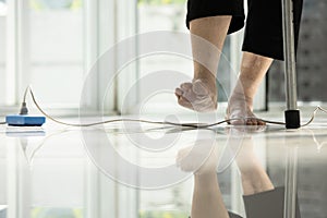 Electrical cord or socket cluttered on the floor,feet of senior woman stepping over obstacles,elderly people walking with