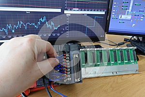 An electrical engineer checks the connection of the PLC automaton. Control system testing.