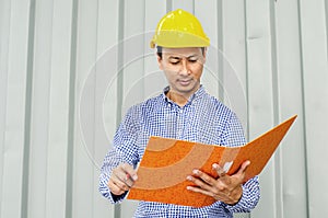 Electrical Engineer holding files while wearing a personal protective equipment safety helmet