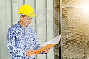 Electrical Engineer holding files while wearing a personal protective equipment safety helmet