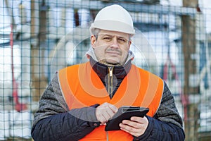 Electrical Engineer with tablet PC near the electric substation