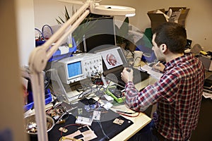 Electrical Engineer Testing Component At Work Bench