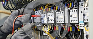 Electrical engineer using digital multi-meter measuring equipment to checking electric current voltage at circuit breaker