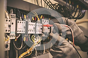 Electrical engineer using digital multi-meter measuring equipment to checking electric current voltage at circuit breaker