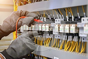 Electrical engineer using digital multi-meter to check current voltage