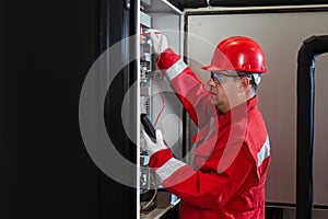 Electrical engineer using digital multimeter measuring equipment to checking electric current voltage