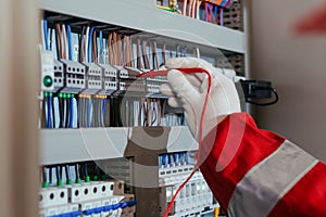 Electrical engineer using digital multimeter measuring equipment to checking electric current voltage