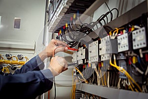 Electrical engineer using measuring equipment to checking electric current voltage at circuit breaker and cable wiring system ,