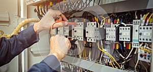 Electrical engineer using measuring equipment to checking electric current voltage at circuit breaker and cable wiring system ,