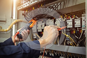 Electrical engineer using measuring equipment to checking electric current voltage at circuit breaker and cable wiring system ,